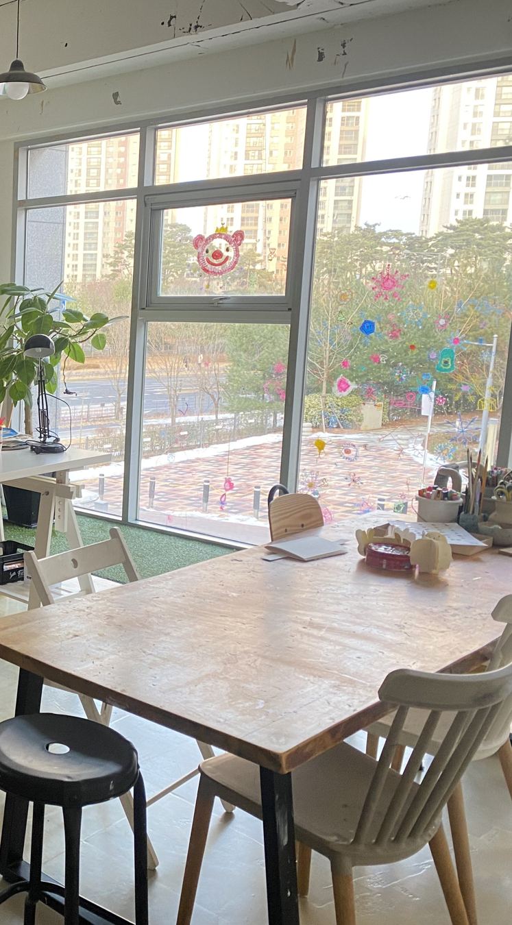 큰 창으로 볕이 드는 작업실 테이블