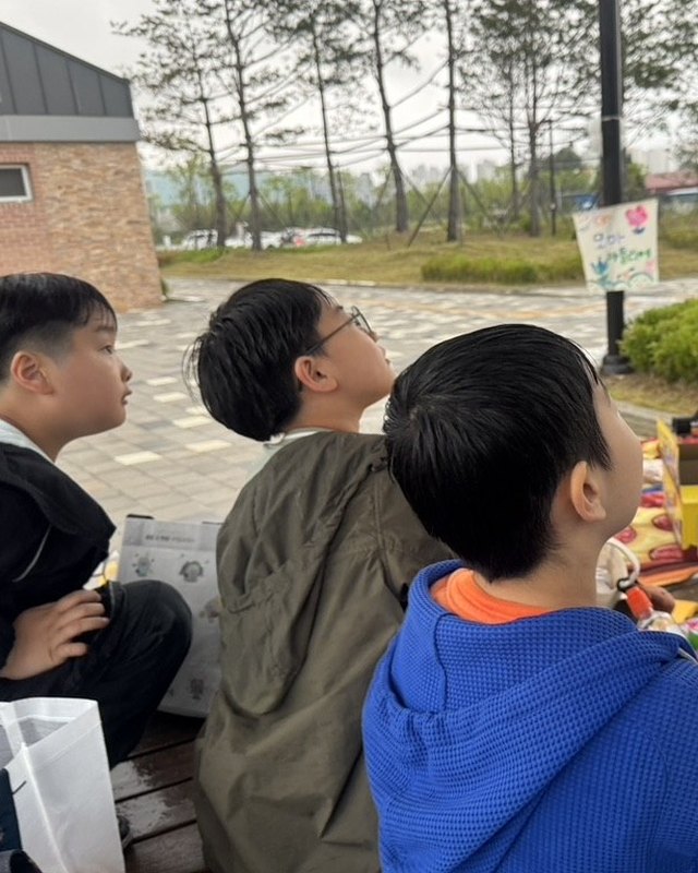 공원 정자에 앉아 그림을 그리는 아이들